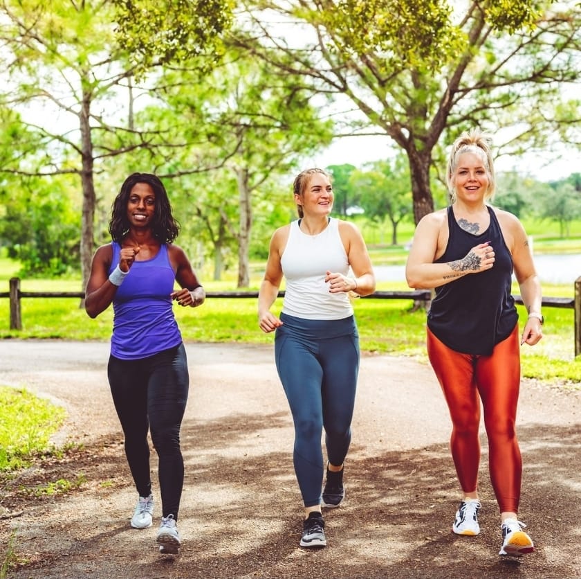 امرأة تمشي بين الأشجار في مسار طبيعي هادئ